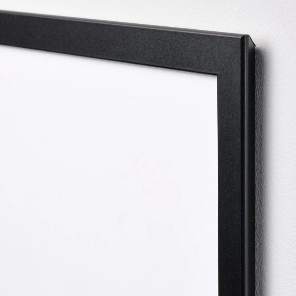 Duvar üzerinde duran, modern ve minimalist tasarıma sahip siyah çerçeveli tablo detayı.